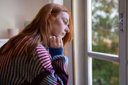 woman with depression at window